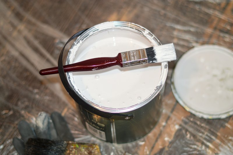 白い塗料の缶にのせたハケ(イメージ写真)